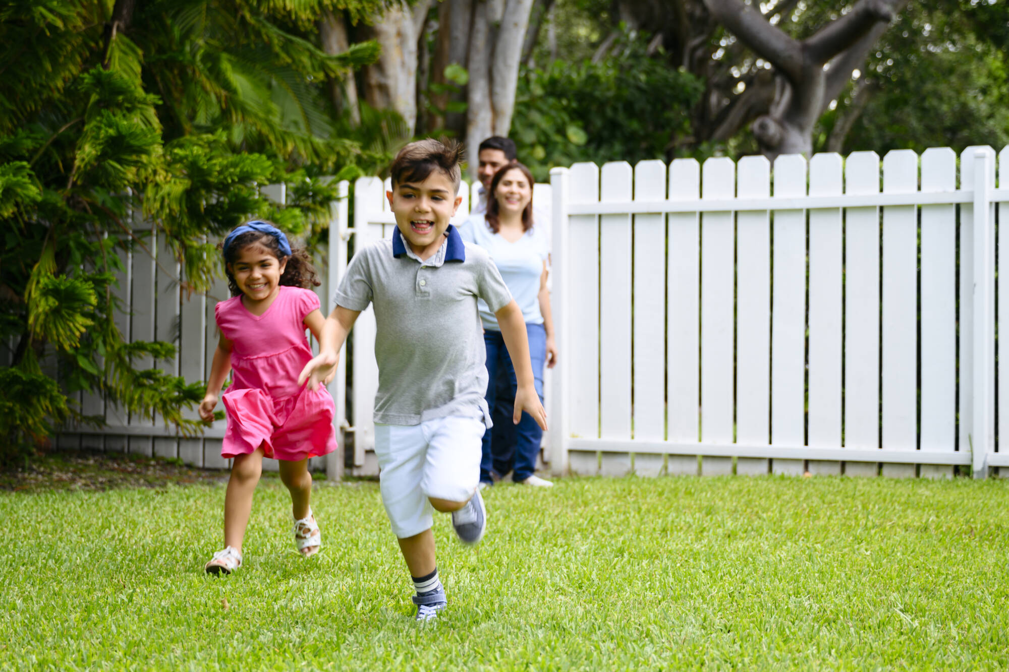 Energetic Hispanic children returning home with parents Fence Installation Near Me